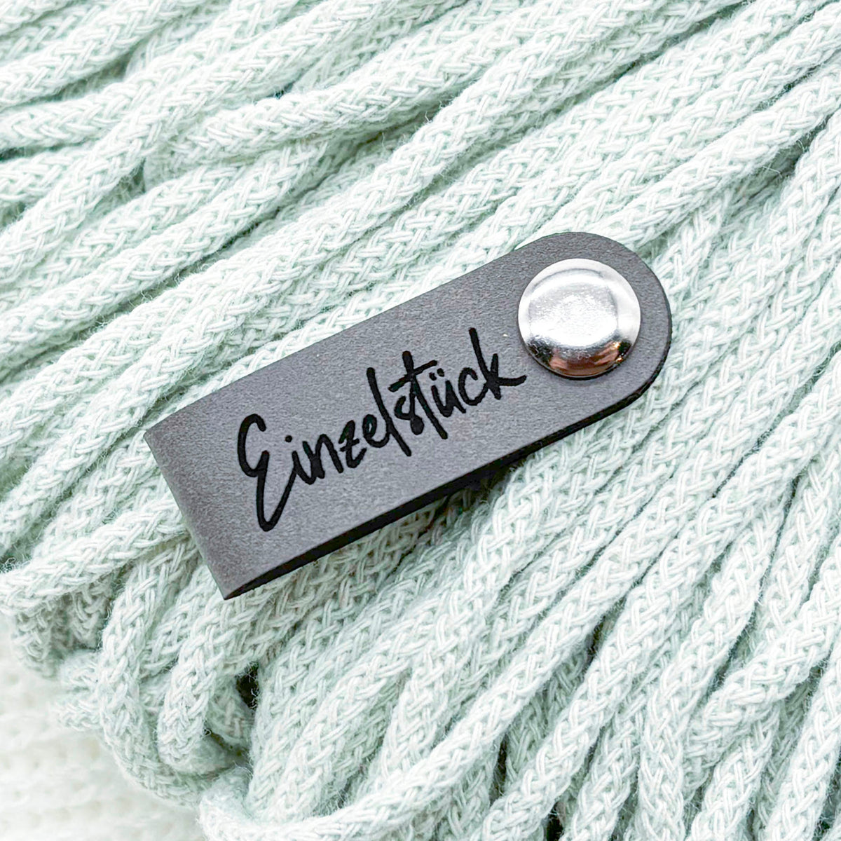 Drei Befestigungsarten für Kunstleder-Labels: Annähen, Chicago Screws und Faltlabel