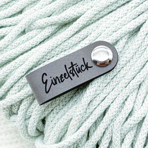 Drei Befestigungsarten für Kunstleder-Labels: Annähen, Chicago Screws und Faltlabel